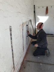 installing installstrips on brick wall